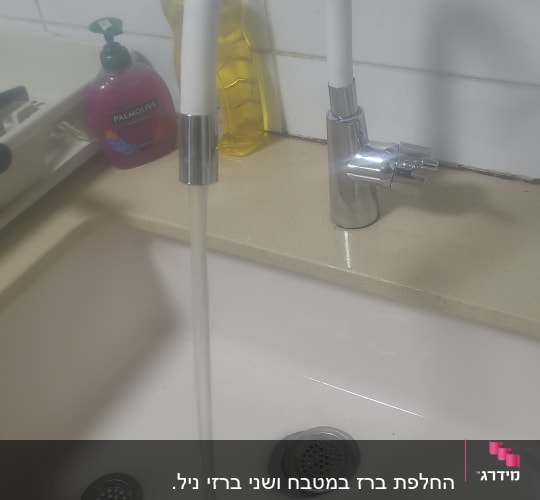 ברז מים זורם בכיור מטבח לבן